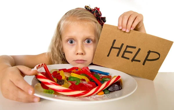 Little female child nutrition abuse of sweet and sugar in candy unhealthy food asking for help — Stockfoto