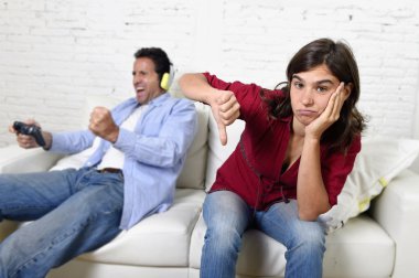 woman  angry and upset while husband or boyfriend plays videogames ignoring her