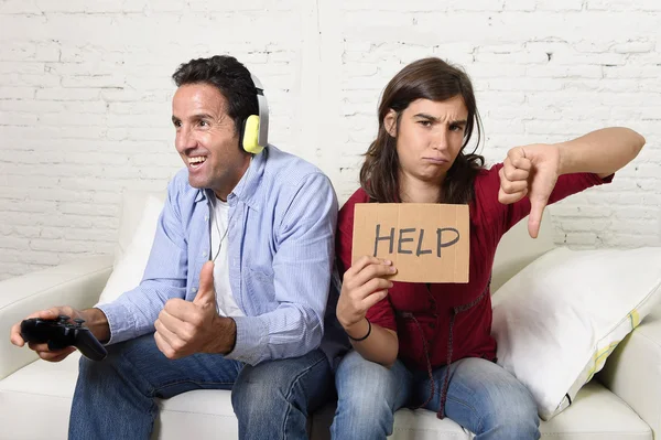 Woman asking for help angry upset while husband or boyfriend plays videogames ignoring her — Stock fotografie