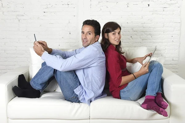 Пара на дивані ігнорує один одного за допомогою мобільного телефону та цифрового планшета в інтернет-залежності — стокове фото