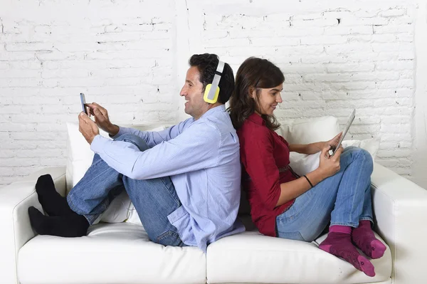 Пара на дивані ігнорує один одного за допомогою мобільного телефону та цифрового планшета в інтернет-залежності — стокове фото
