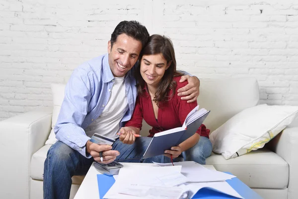 Attraktives Paar, das zu Hause Schulden abrechnet, glücklich über finanziellen Erfolg und Reichtum — Stockfoto