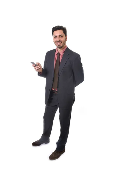 Корпоративный портрет молодого привлекательного бизнесмена латиноамериканской национальности, улыбающегося с помощью мобильного телефона — стоковое фото