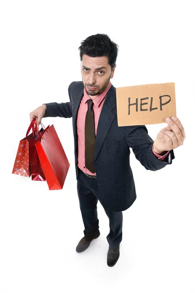 Mladá atraktivní obchodní muž v napětí drží mnoho nákupních tašek a pomoc znamení pohledu unavený nudil a strach — Stock fotografie
