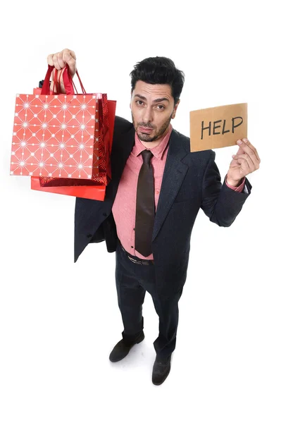 年轻有吸引力的商业男子在应力持有大量购物袋和帮助标志看上去很疲惫无聊担心 — 图库照片