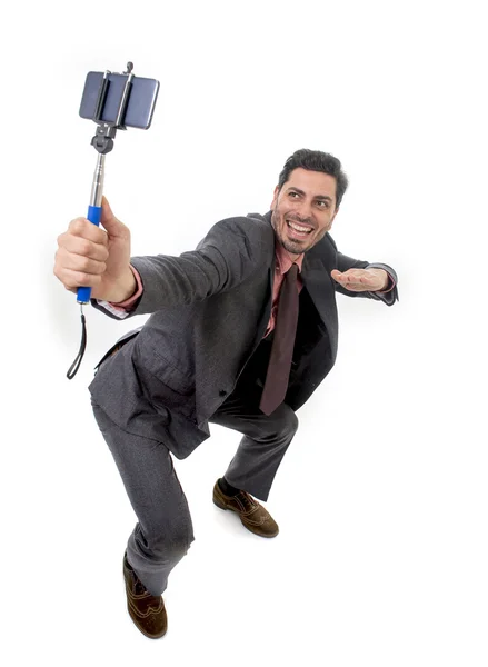 Joven atractivo hombre de negocios en traje y corbata tomando foto selfie con la cámara del teléfono móvil y palo posando feliz — Foto de Stock