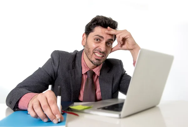 Attractive businessman at office desk working on computer laptop looking tired and busy — Stock fotografie