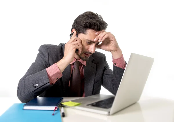 Ocupado homem de negócios trabalhando em estresse no computador portátil falando no telefone móvel — Fotografia de Stock
