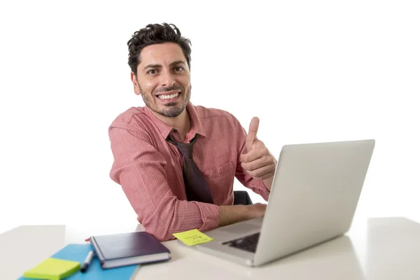 Homem de negócios atraente em camisa e gravata sentado na mesa de escritório trabalhando com laptop de computador dando polegar para cima — Fotografia de Stock