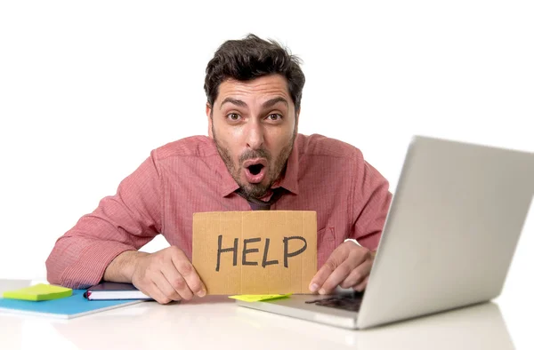 Podnikatel v kanceláři pracuje na přenosný počítač s žádostí o pomoc, držící lepenky znamení pohledu, smutný a depresivní — Stock fotografie