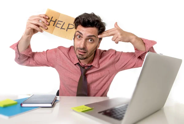 Hombre de negocios en el escritorio de la oficina trabajando en computadora portátil pidiendo ayuda sosteniendo cartel de cartón buscando triste y deprimido — Foto de Stock