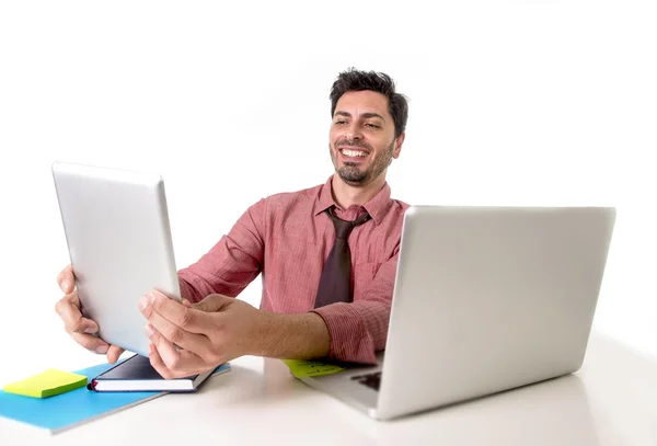 Geschäftsmann, der am Schreibtisch mit digitalem Tablet-PC arbeitet, lächelt zufrieden vor dem Computer-Laptop sitzend und sieht zufrieden aus — Stockfoto