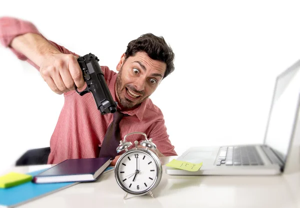 Бизнесмен в стрессе на рабочем столе компьютера указывая ручной пистолет к будильнику в вне времени и срок проекта истекает — стоковое фото