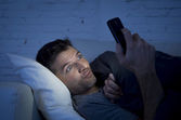 Mann im Bett Couch zu Hause spät in der Nacht mit Handy bei schwachem Licht Online-Pornos ansehen