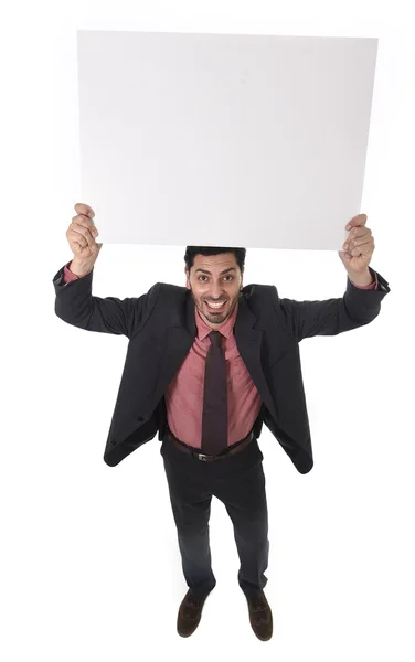 Joven atractivo hombre de negocios en traje y corbata sosteniendo cartelera blanca en blanco o panel de publicidad — Foto de Stock