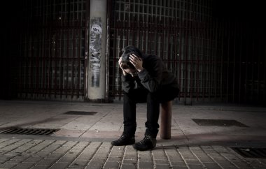 sad woman alone on street suffering depression desperate and helpless wearing hoodie