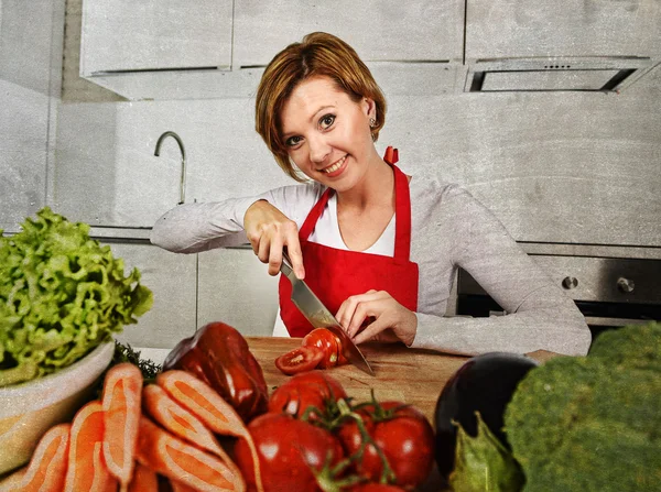 Mulher feliz em casa cozinha preparando salada de legumes com cenouras de alface e cortando tomate — Fotografia de Stock