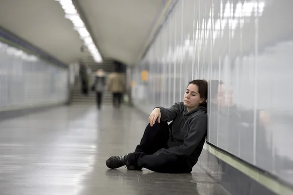 Joven triste mujer en el dolor solo y deprimido en metro urbano túnel suelo preocupado sufrimiento depresión —  Fotos de Stock