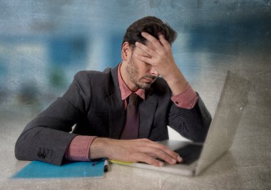 worried businessman with headache working on computer desperate in work stress