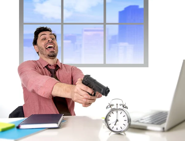 Businessman in stress at office computer pointing hand gun to alarm clock project deadline expiring — ストック写真