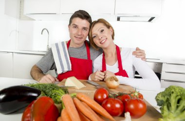 young beautiful couple working at home kitchen preparing vegetable salad together smiling happy