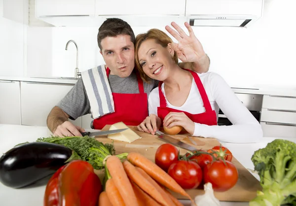 Young beautiful couple working at home kitchen preparing vegetable salad together smiling happy — Stockfoto