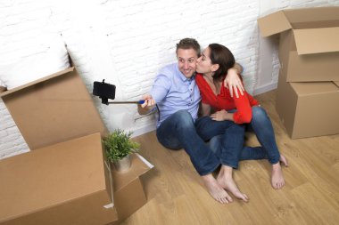 young happy American couple sitting on floor celebrating moving 