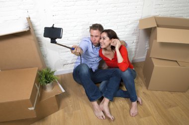 happy couple sitting on floor celebrating moving in new house ta