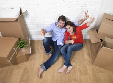 happy American couple sitting on floor unpacking together celebr