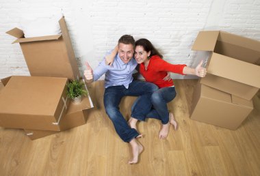 happy American couple sitting on floor kissing celebrating movin