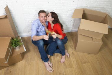 American couple sitting on floor kissing and celebrating with ch
