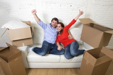 happy American couple lying on couch together celebrating moving