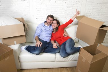happy American couple lying on couch together celebrating moving