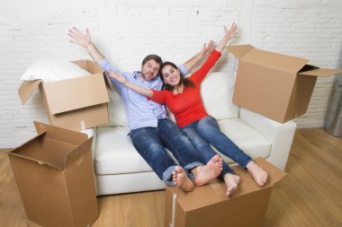 happy American couple lying on couch together celebrating moving