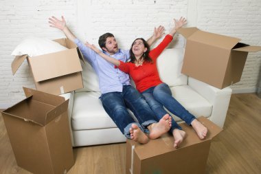 happy American couple lying on couch together celebrating moving