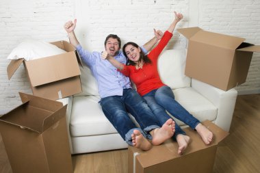 happy American couple lying on couch together celebrating moving