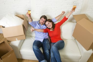 happy American couple lying on couch together celebrating moving