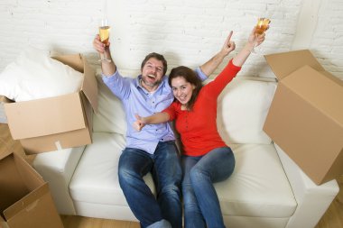 happy American couple lying on couch together celebrating moving
