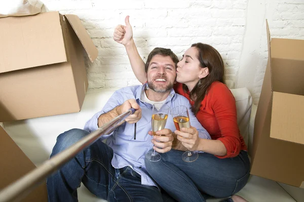 Feliz pareja en sofá divirtiéndose juntos celebrando champán — Foto de Stock