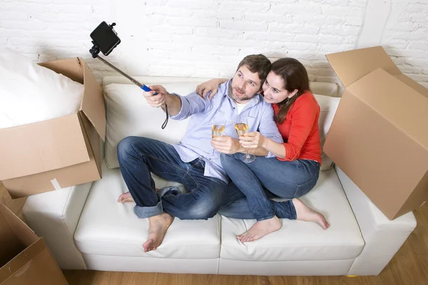 Happy couple on couch having fun together celebrating champagne — 图库照片