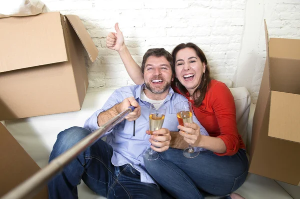 Happy couple on couch having fun together celebrating champagne — Stockfoto