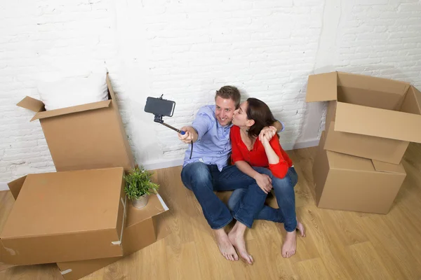Young happy couple sitting on floor celebrating moving in new ho — 图库照片
