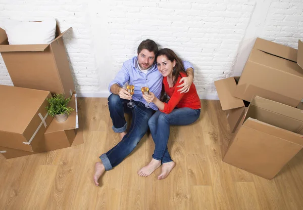 Happy American couple sitting on floor unpacking together celebr — стокове фото