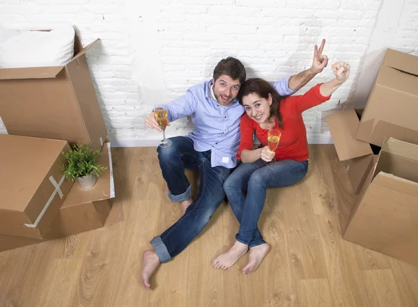 Happy American couple sitting on floor unpacking together celebr — Stok fotoğraf