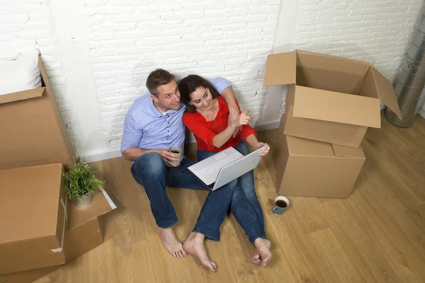 Пара сидить на підлозі, рухаючись в новому будинку або квартирі — стокове фото