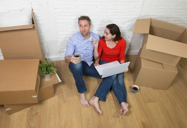 Couple sitting on floor moving in a new house or apartment flat — 图库照片