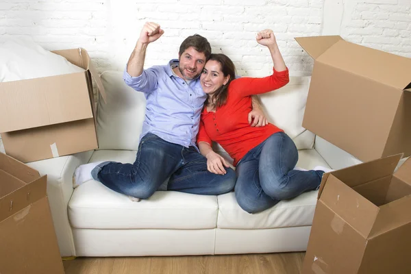 Happy American couple lying on couch together celebrating moving — Stockfoto