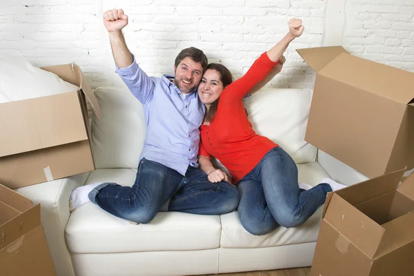 Happy American couple lying on couch together celebrating moving — 图库照片