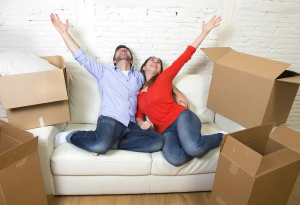 Happy American couple lying on couch together celebrating moving — Stockfoto