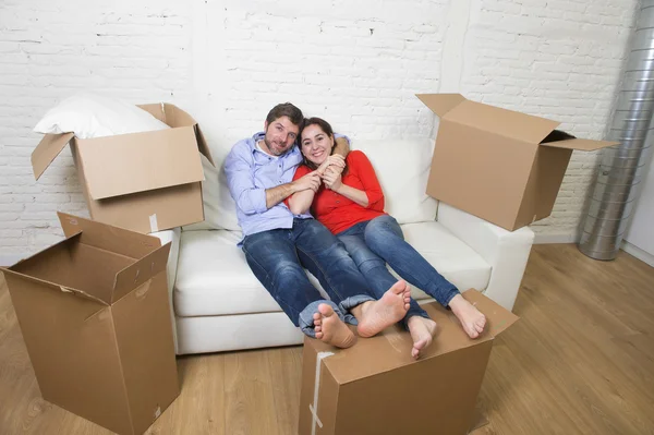 Happy American couple lying on couch together celebrating moving — Stockfoto